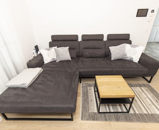 Gemuetliches Sofa im Wohnzimmer mit Holztisch.