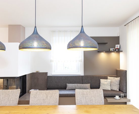 Wohnzimmer mit Esstisch und modernen Lampen.